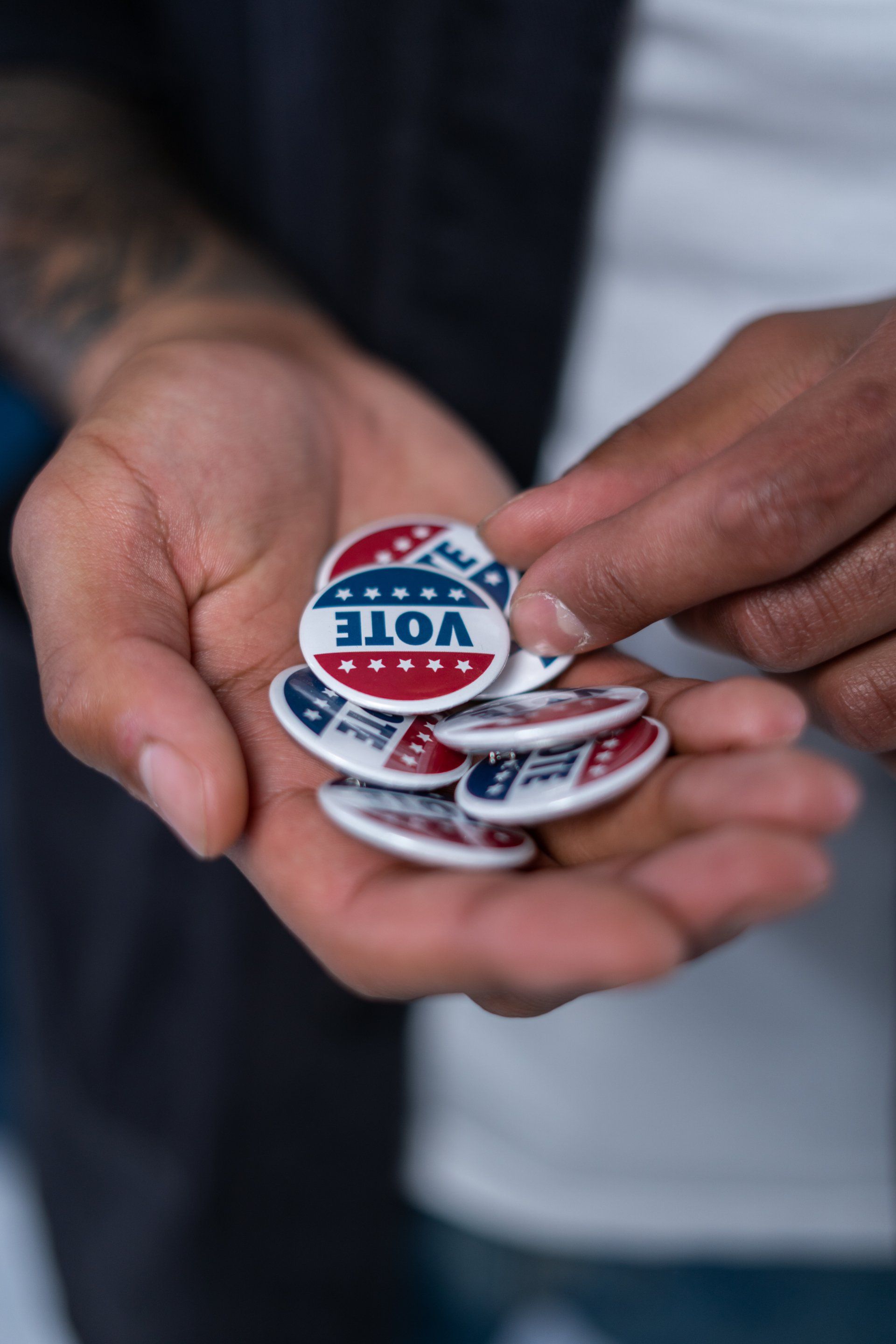 A person is holding a bunch of vote buttons in their hands