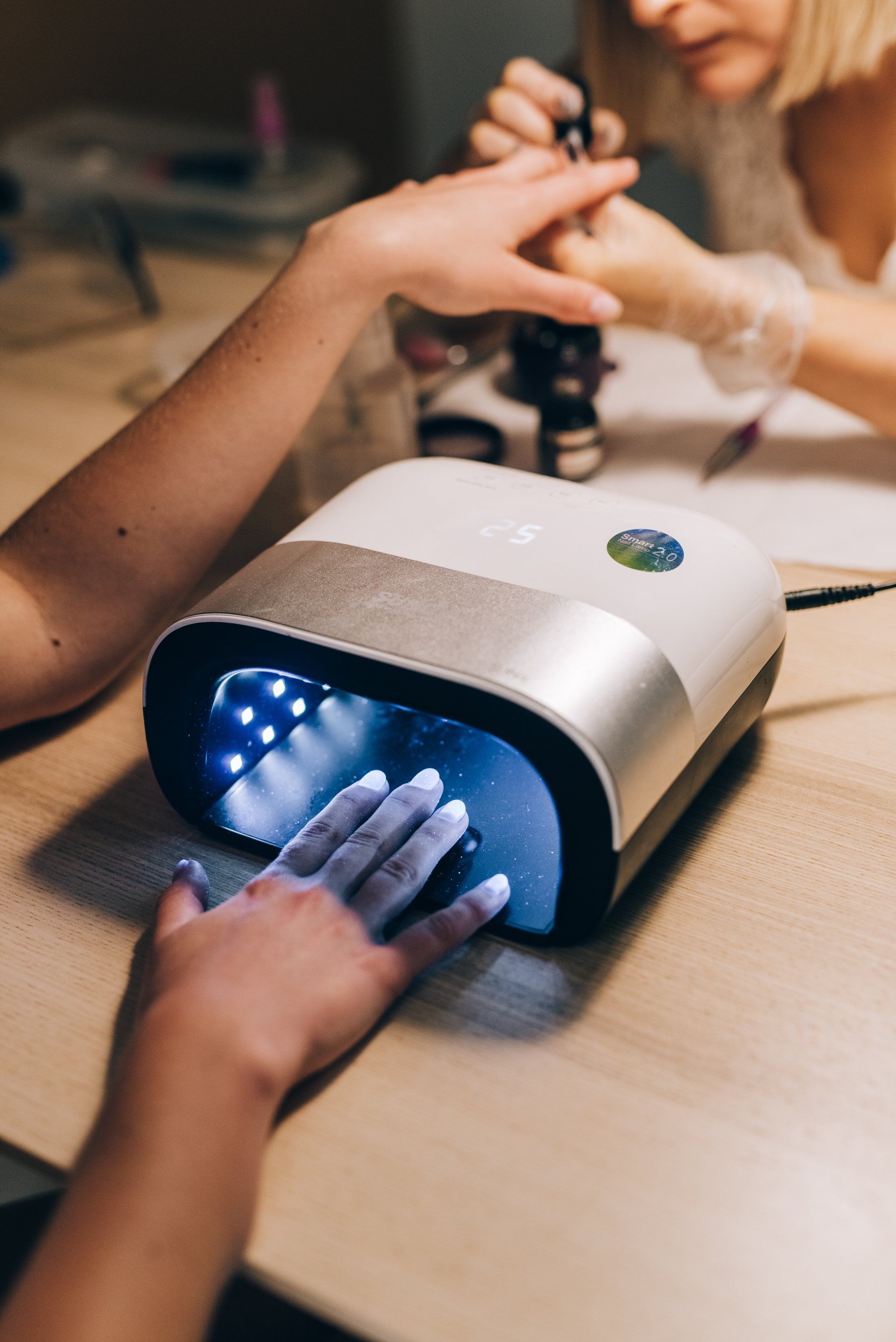A woman is getting her nails done in a nail salon.