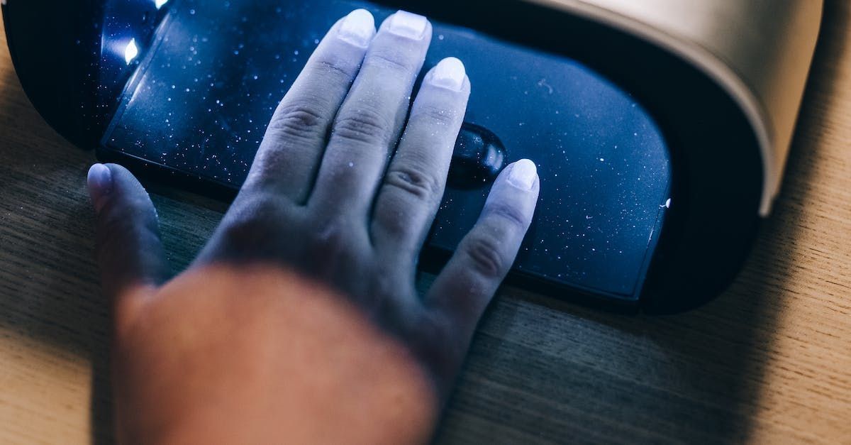 A person is using a nail dryer to dry their nails.