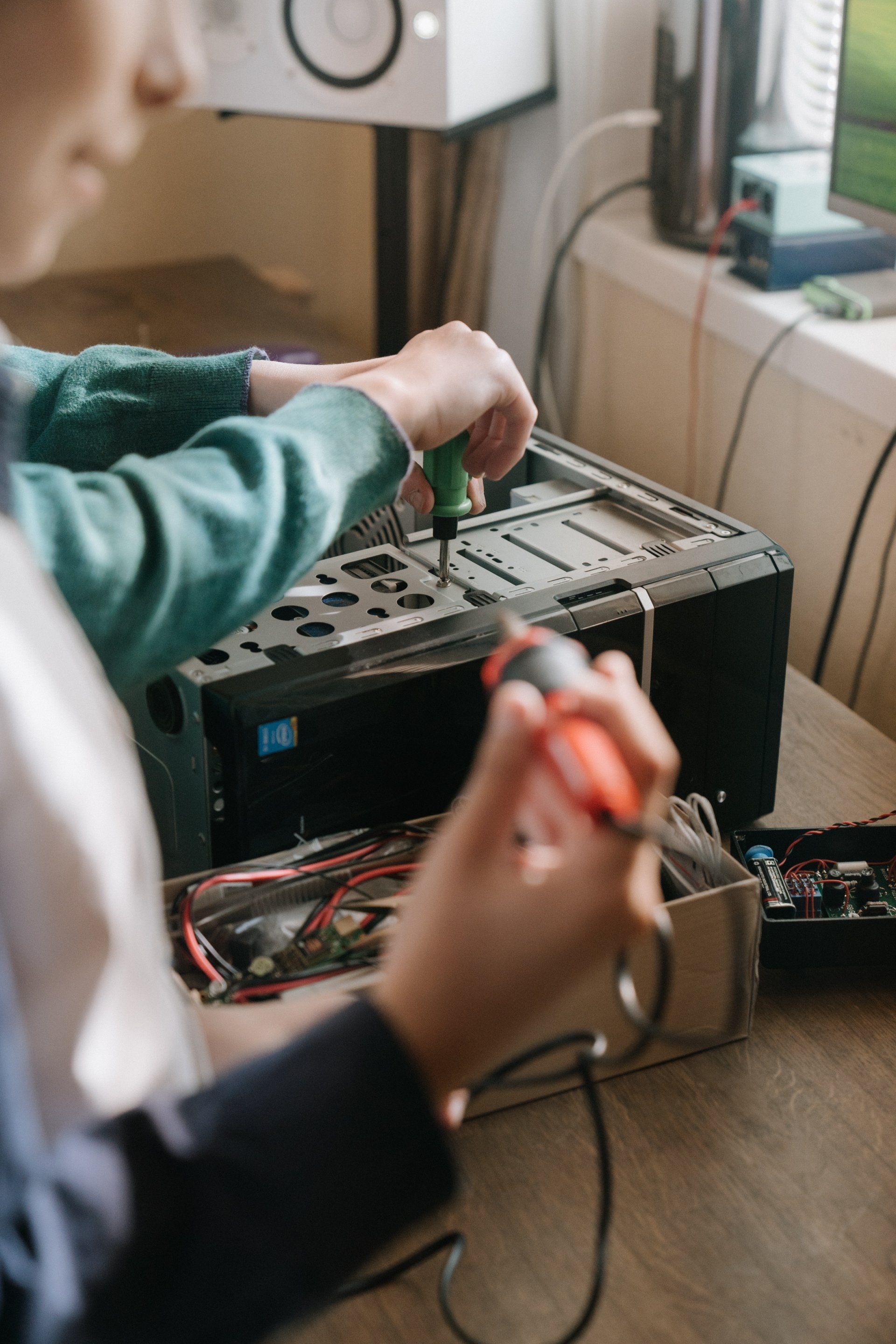 a person is fixing a computer with a screwdriver .