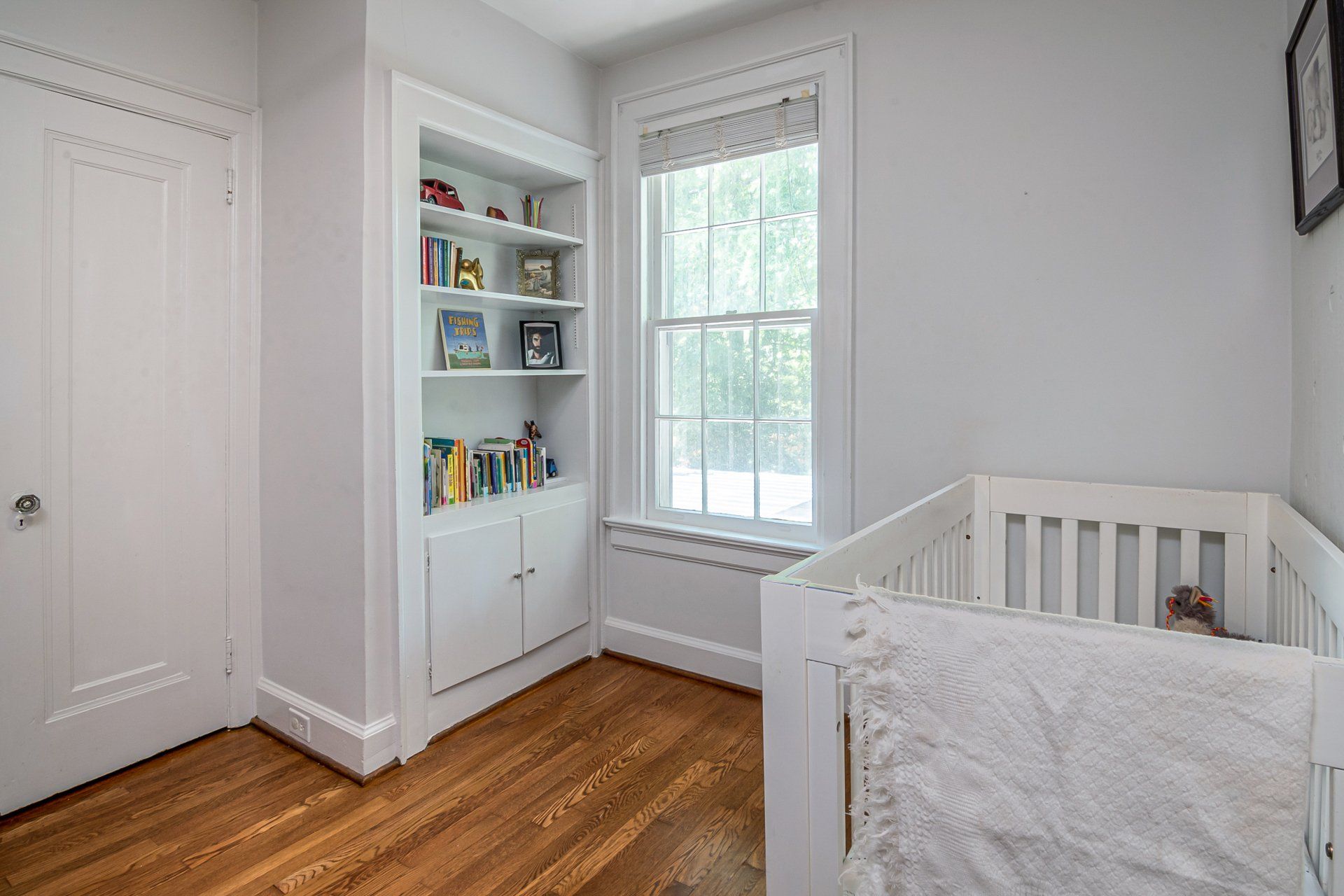 Nursery with large window white walls