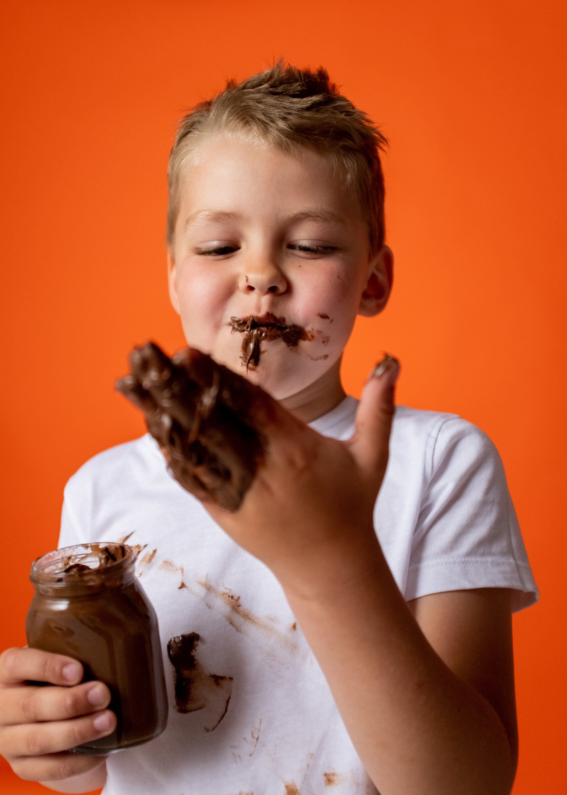 kid eating chocolate with hand