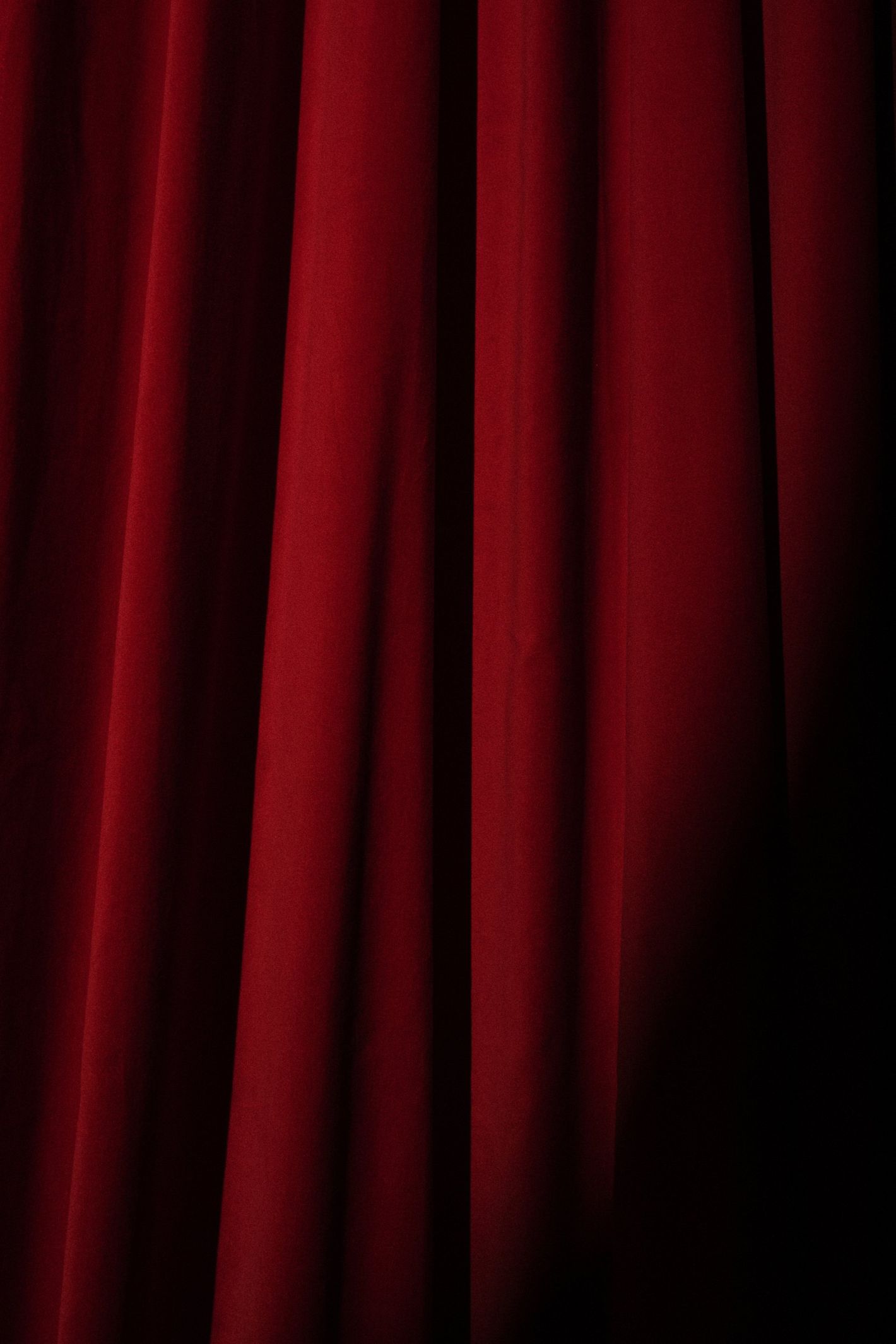un gros plan d' un rideau rouge de théâtre sur fond noir
