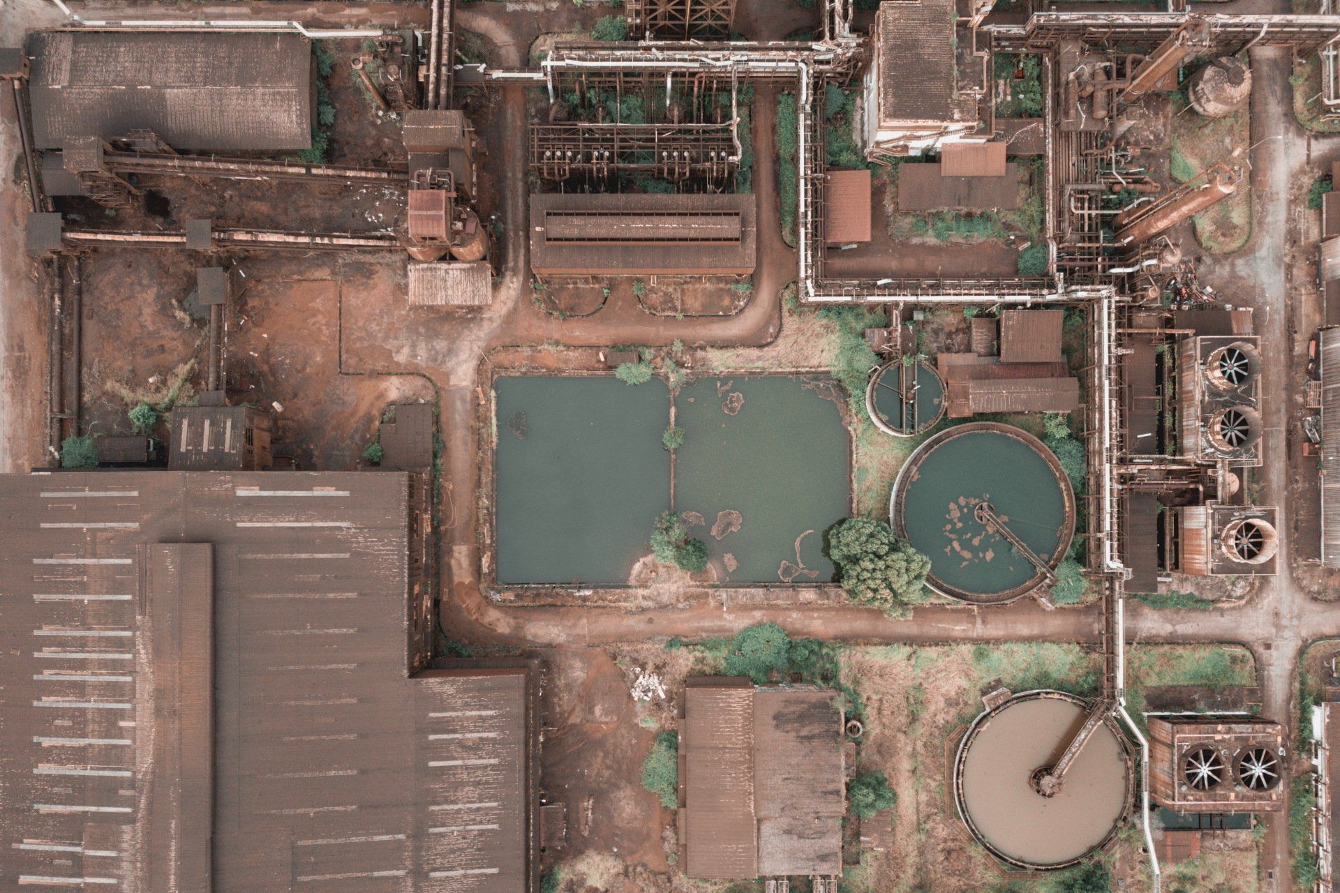 An aerial view of a factory with a lot of buildings and ponds.