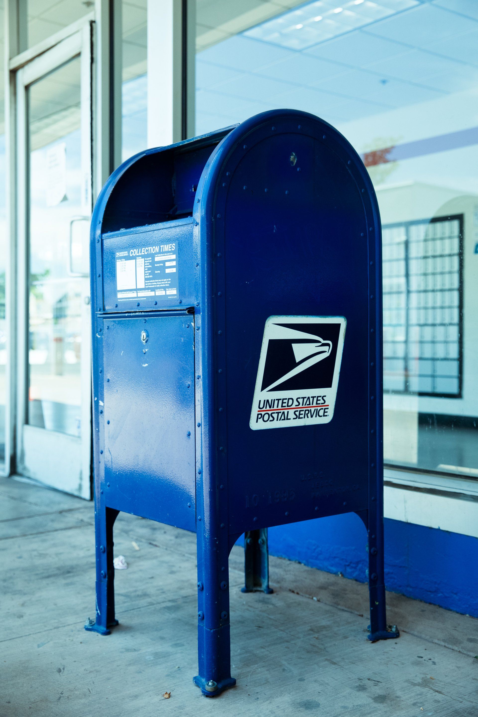 A blue mailbox with the united states postal service logo on it