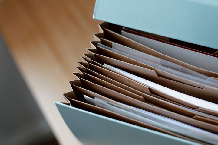 a stack of folders filled with papers on a desk .