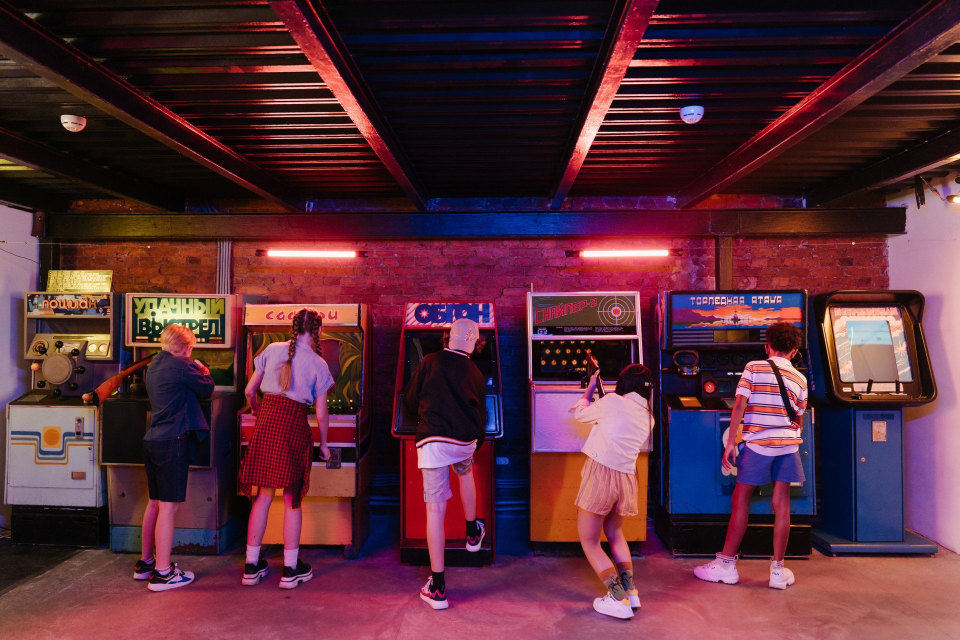 A group of people are playing video games in an arcade.