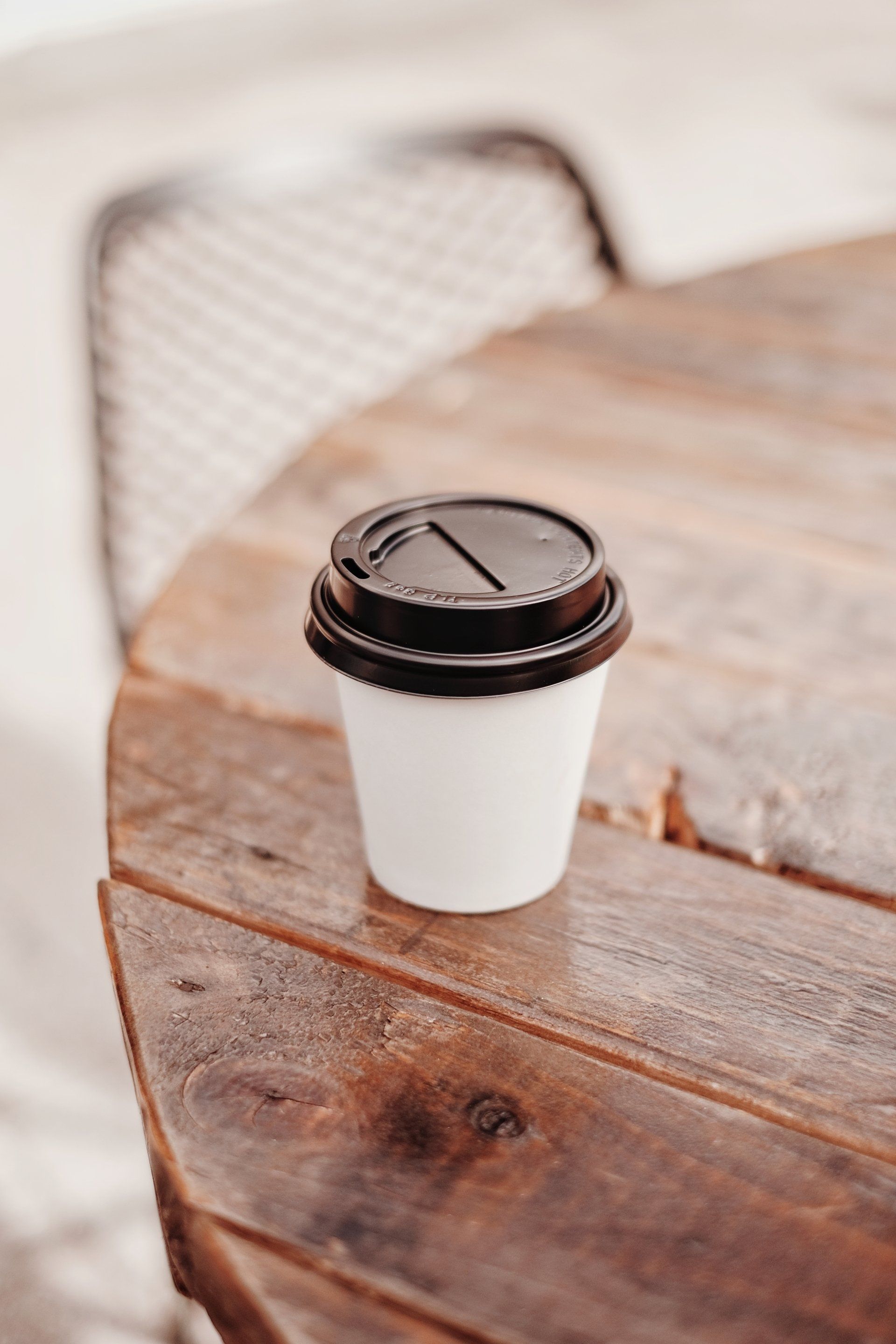 A cup of coffee is sitting on a wooden table.
