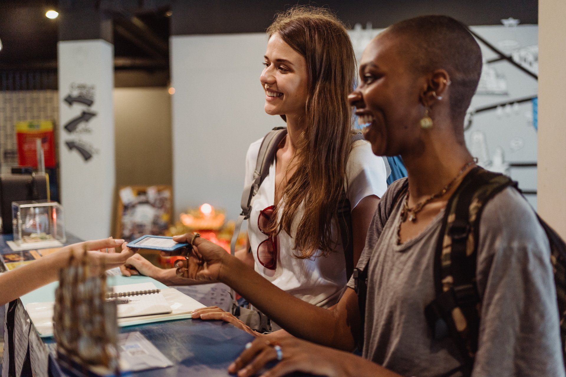 Two women are standing at a counter in a hotel.