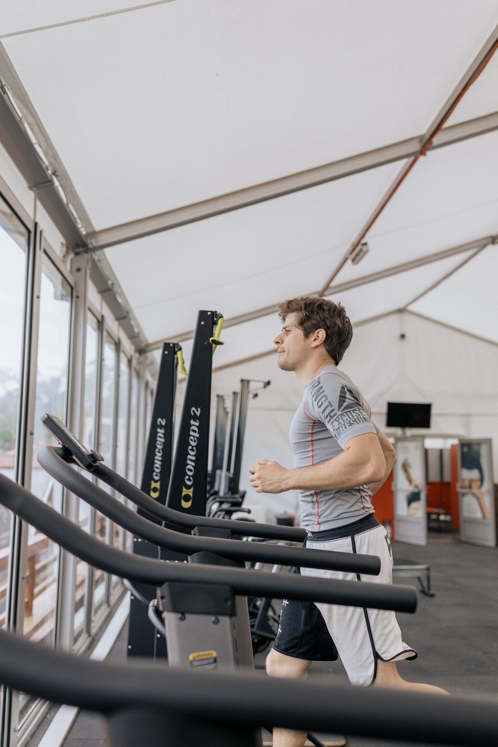 A man is running on a treadmill in a gym.