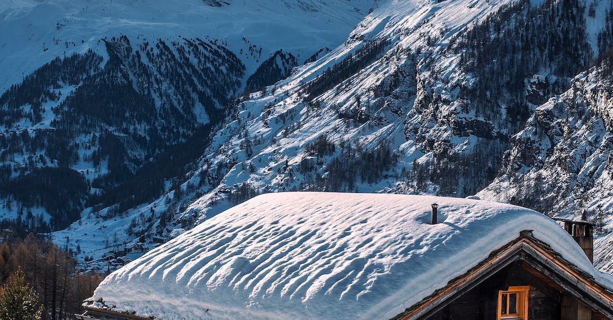 A snow covered roof of a house in the mountains.