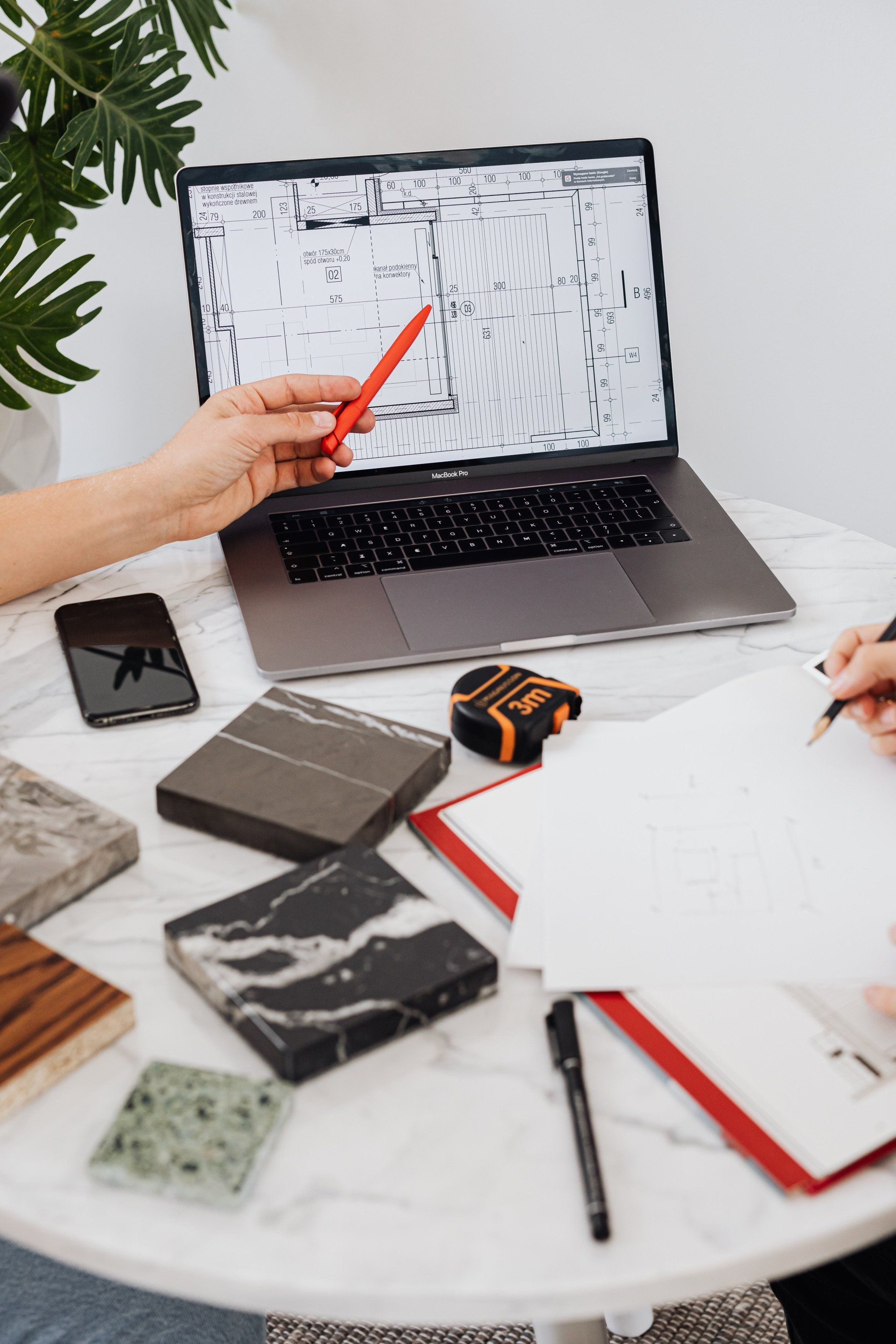 A person is sitting at a table using a laptop computer.