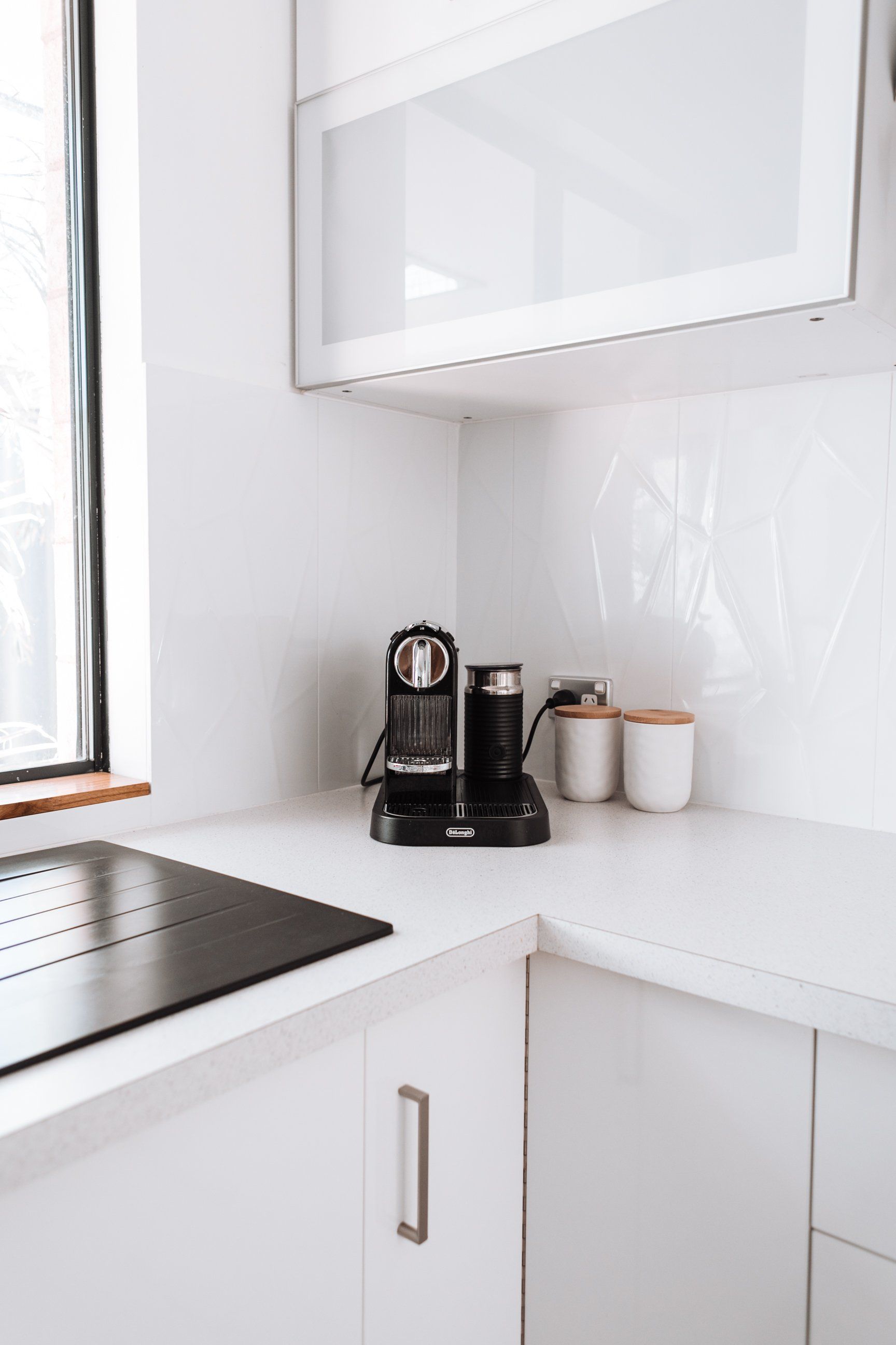 a kitchen with white cabinets and a coffee maker on the counter:  Turn Your Crowded Kitchen Into A Minimalist Space
