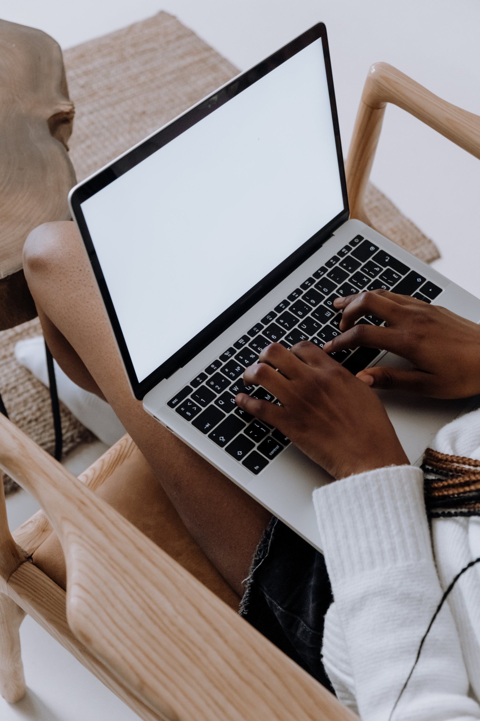 a person is sitting in a chair using a laptop computer