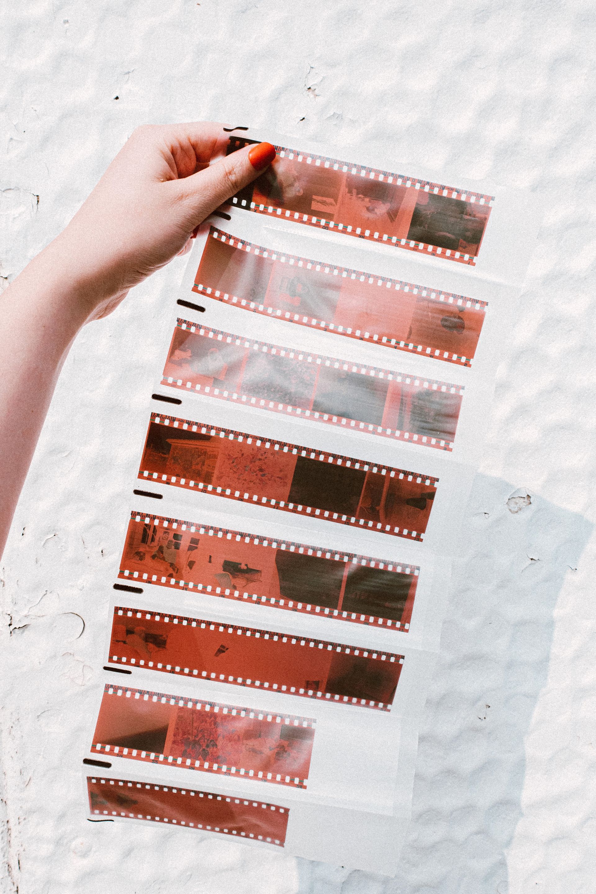 une femme tient un rouleau de film avec des images rouges