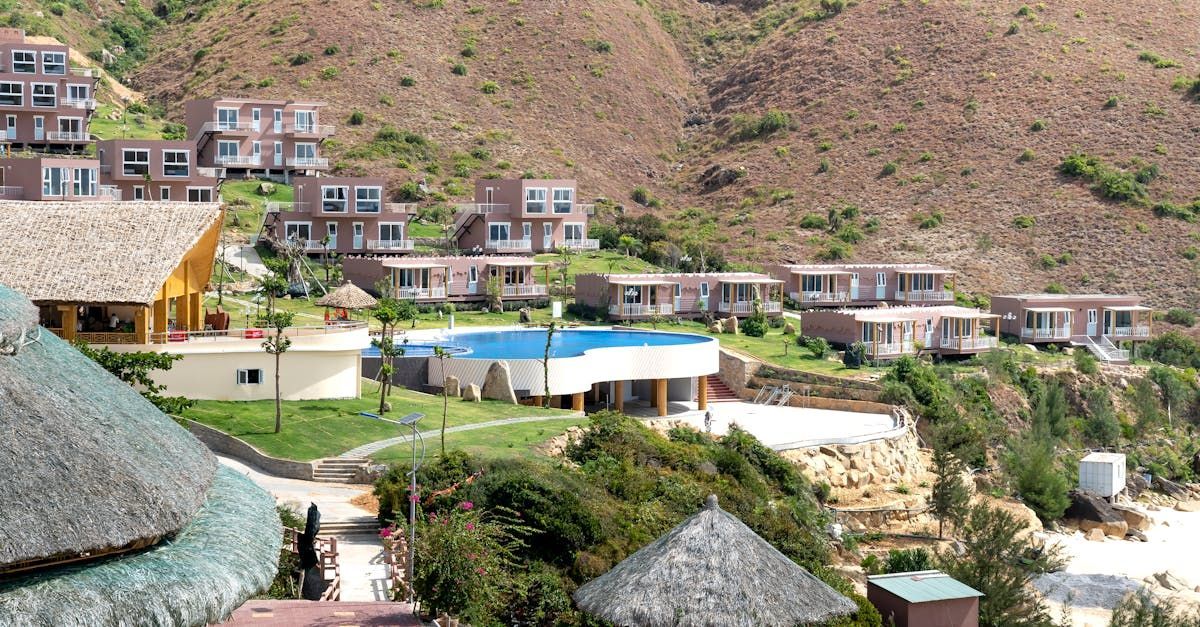 A group of houses on a hillside with a pool in the middle