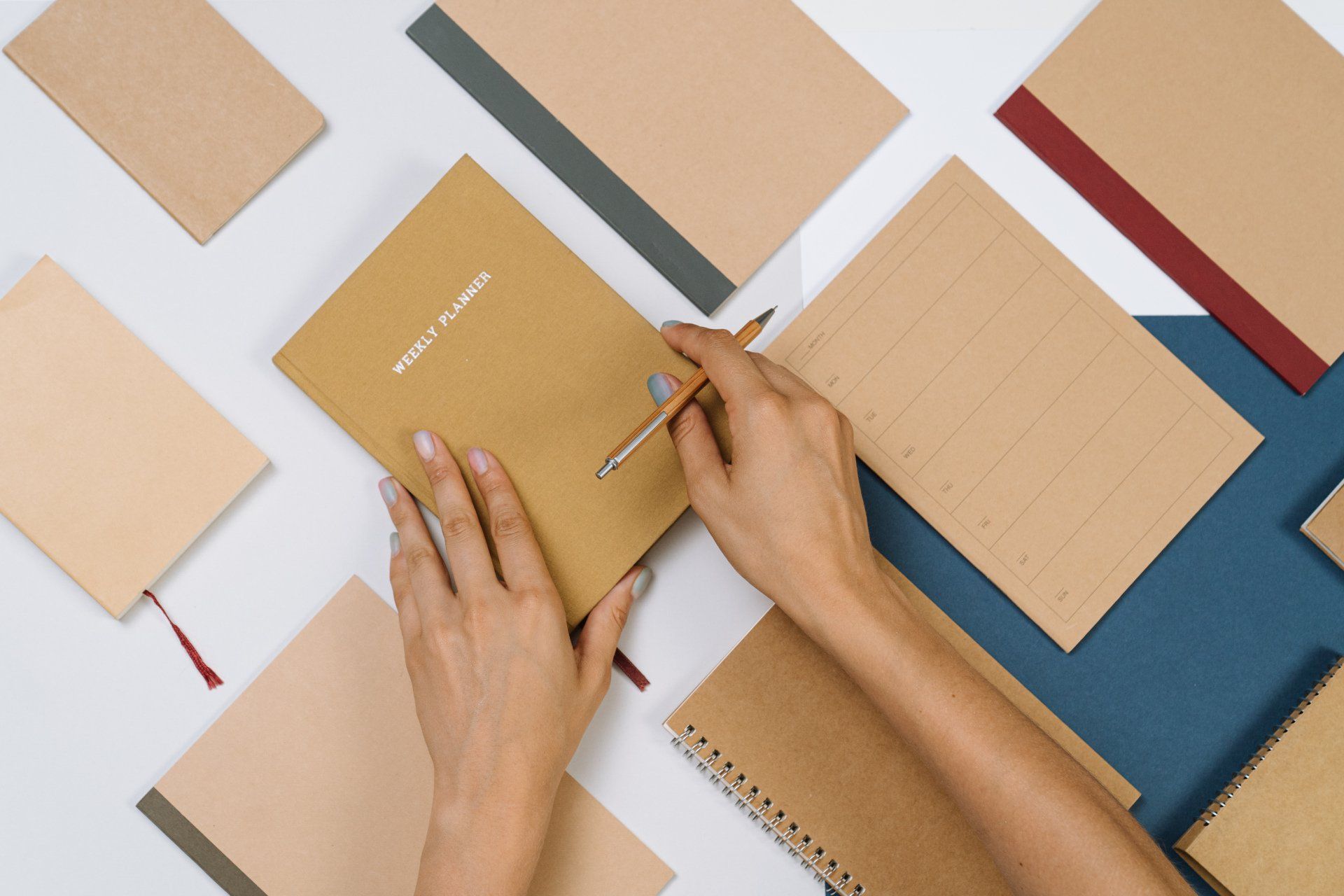 Une personne écrit dans un cahier avec un stylo.