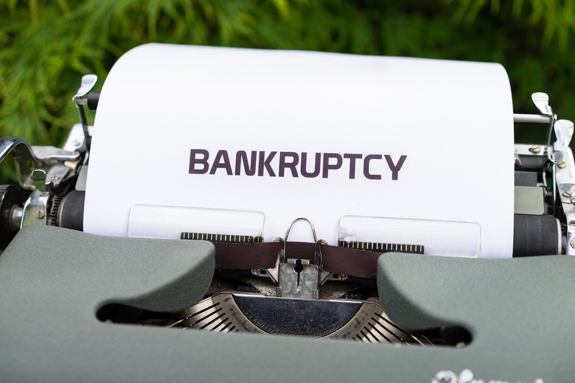 A typewriter with a piece of paper that says bankruptcy on it