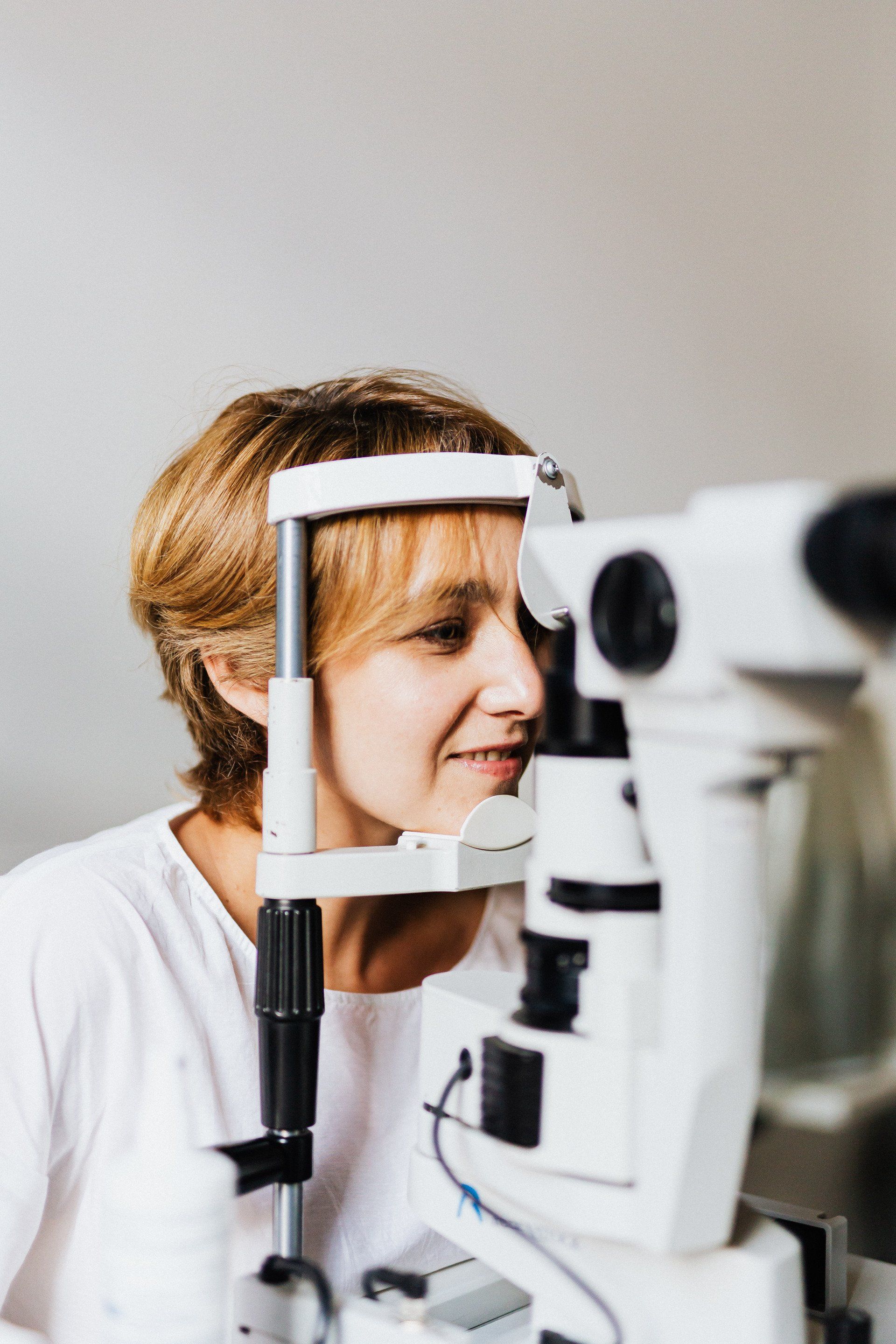 a woman is getting her eyes examined by an ophthalmologist .
