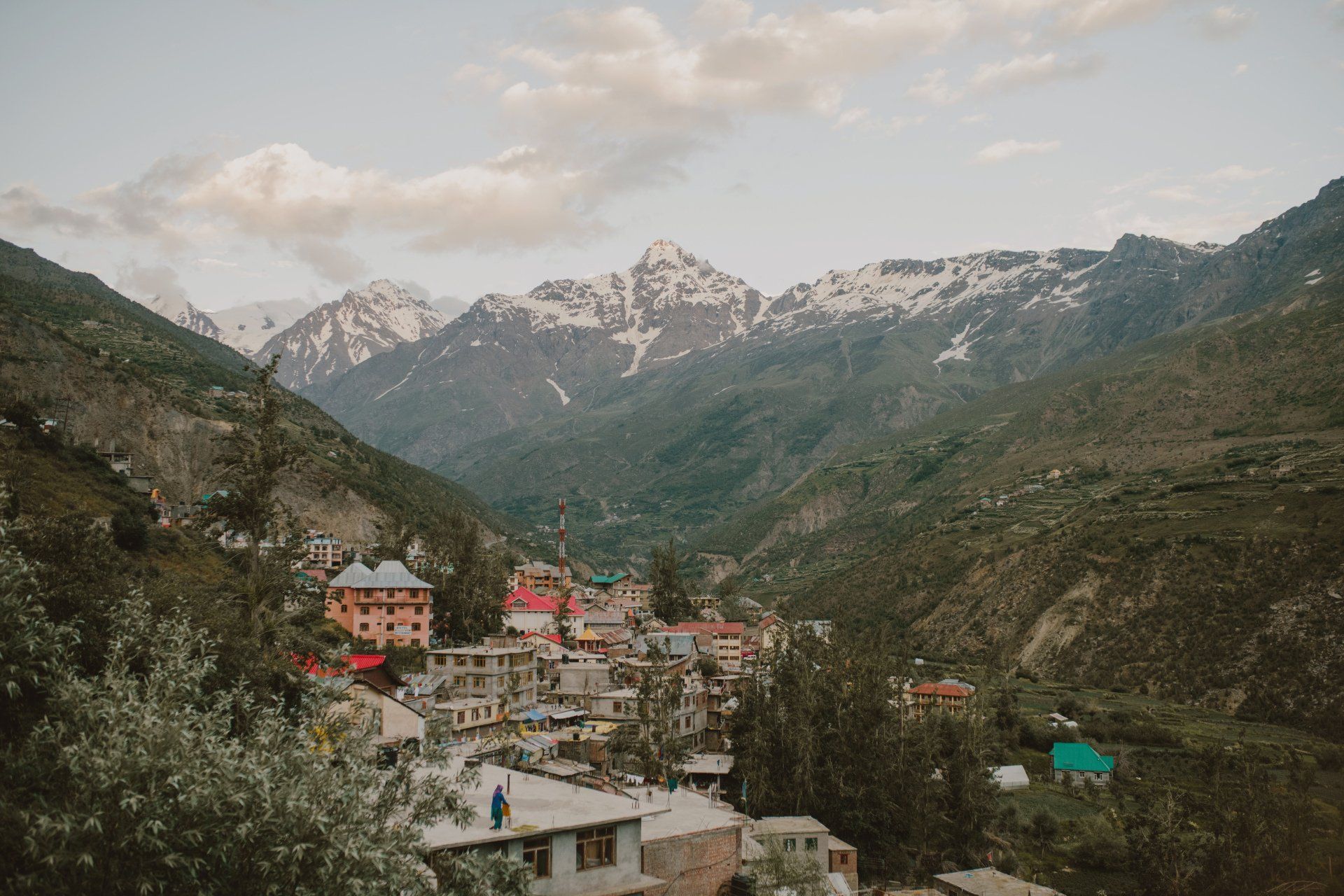 A small town in the middle of a valley with mountains in the background.