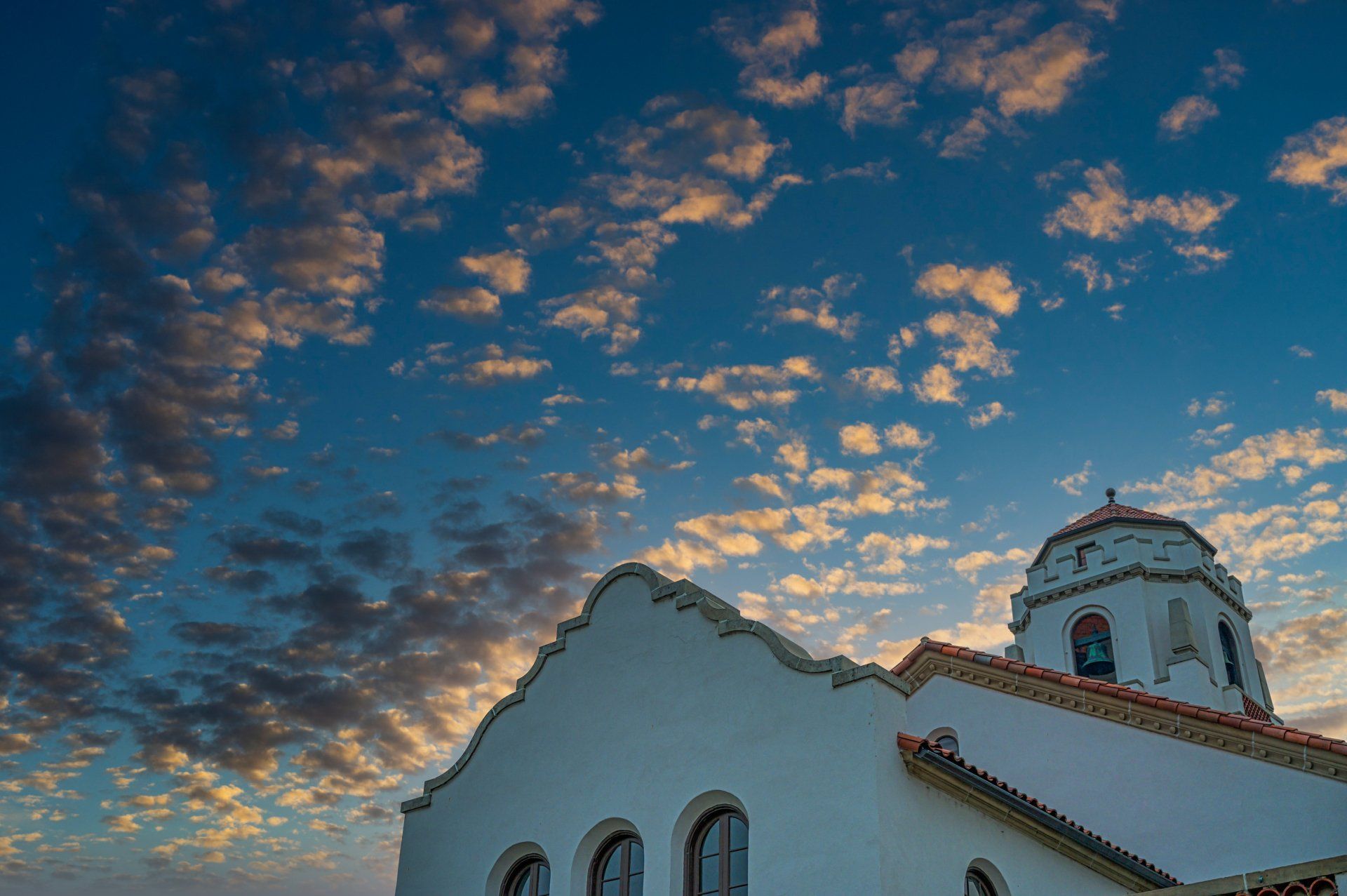 A white church with a blue sky and clouds in the background. Credit Repair 