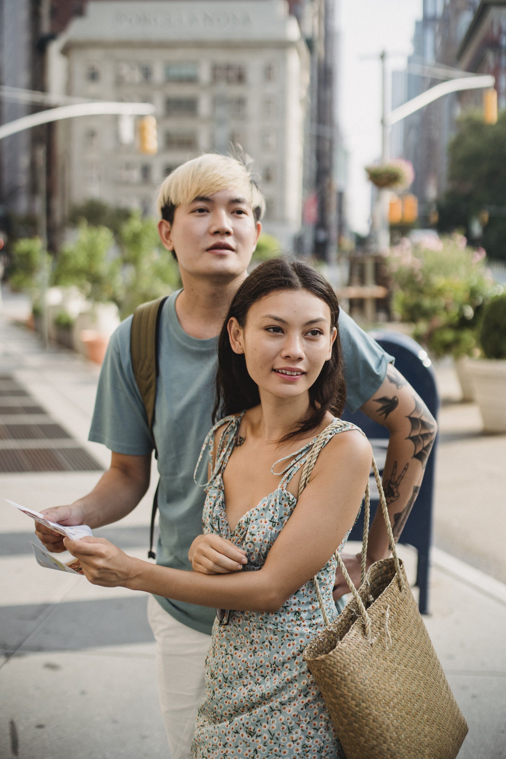 A man and a woman are standing next to each other on a city street.