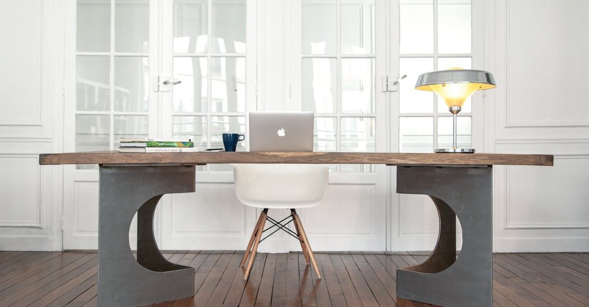 A wooden desk with a chair and a laptop on it.
