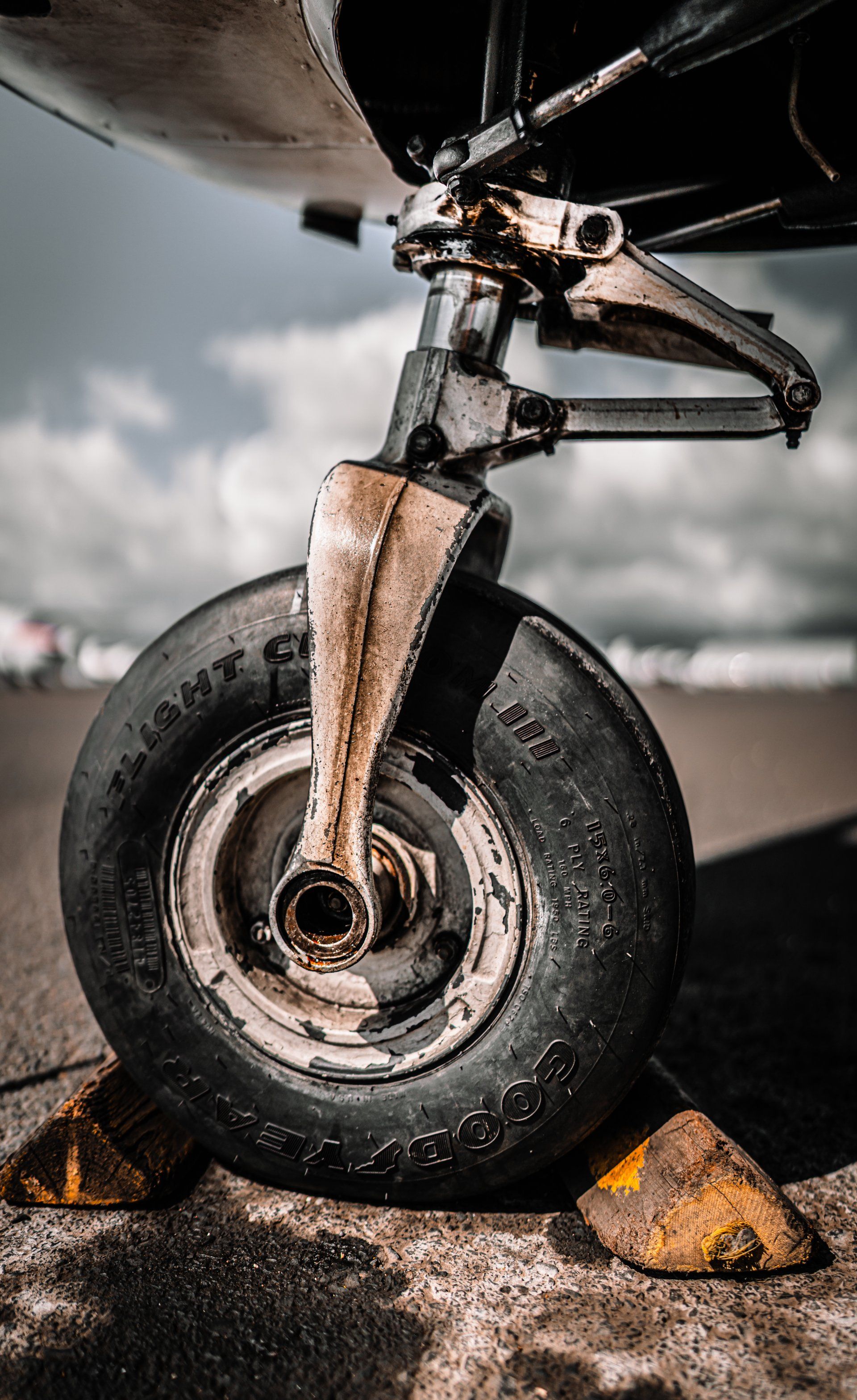 A close up of a plane 's front wheel on a runway.