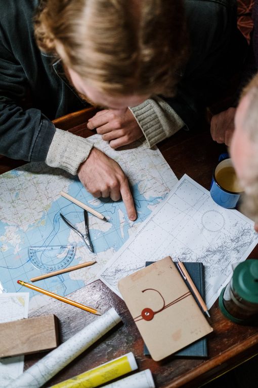 Two people are sitting at a table looking at a map.