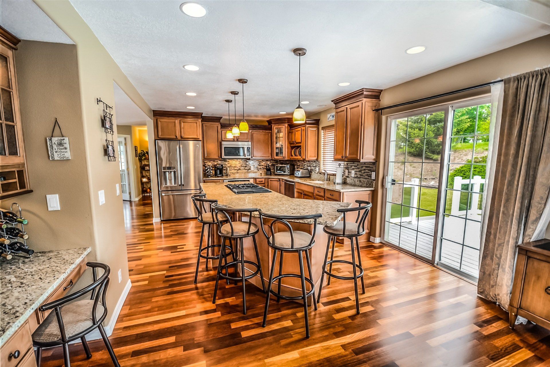 a kitchen with hardwood floors , stainless steel appliances and a large island .