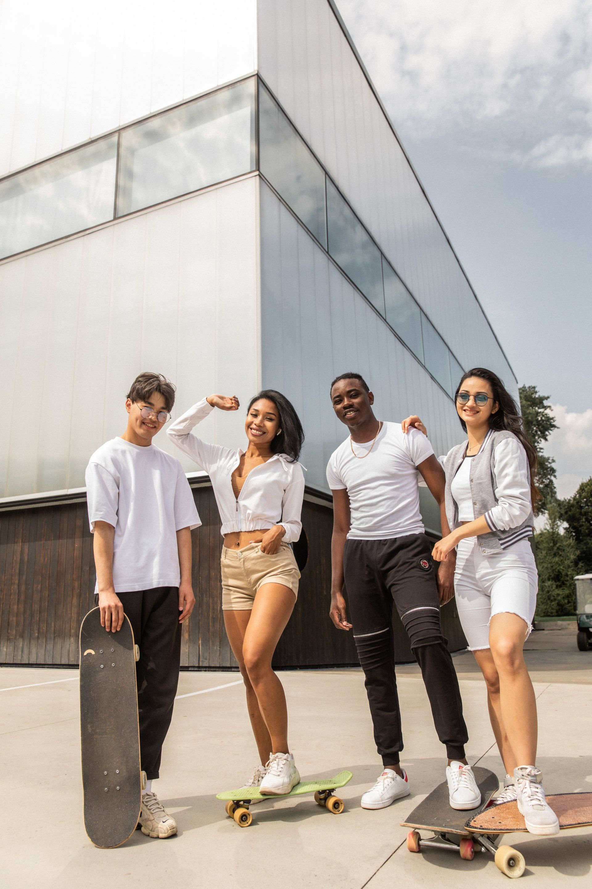 A group of young people are standing next to each other on skateboards.