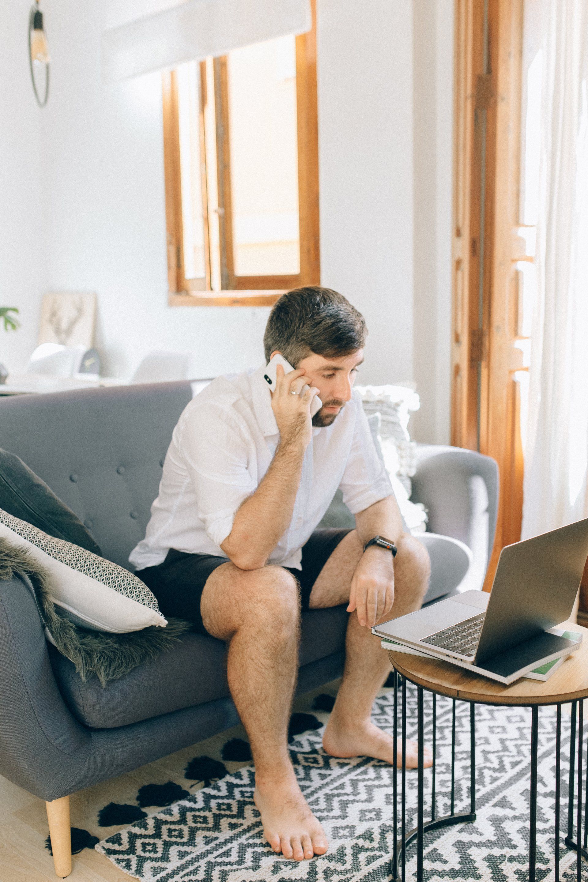 Man talking on the phone while looking at the laptop