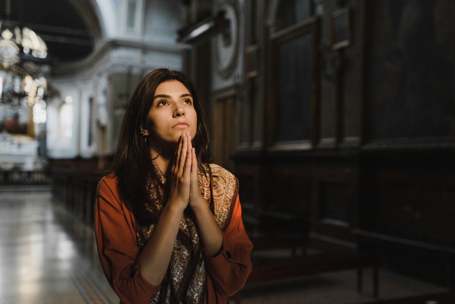 Woman praying in church looking up