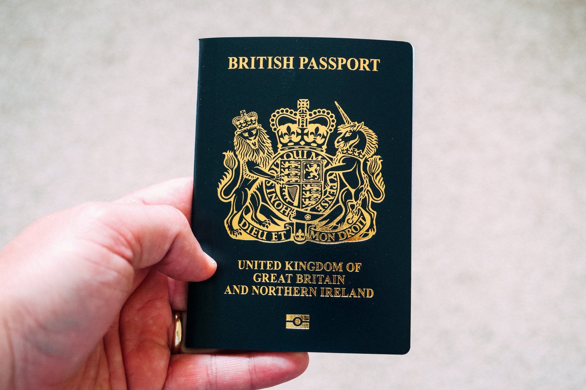 a person is holding a british passport in their hand