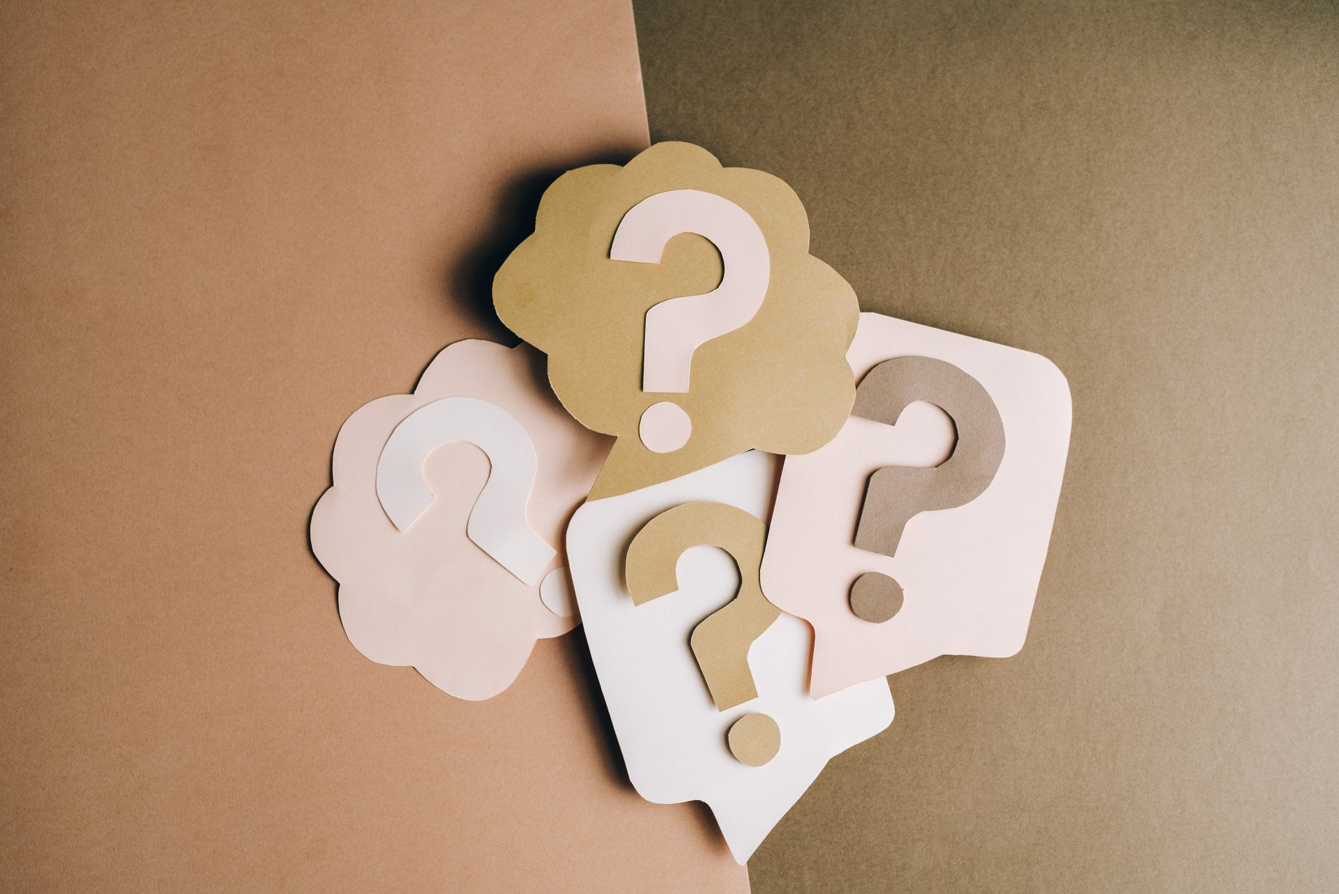 A group of paper speech bubbles with question marks on them.