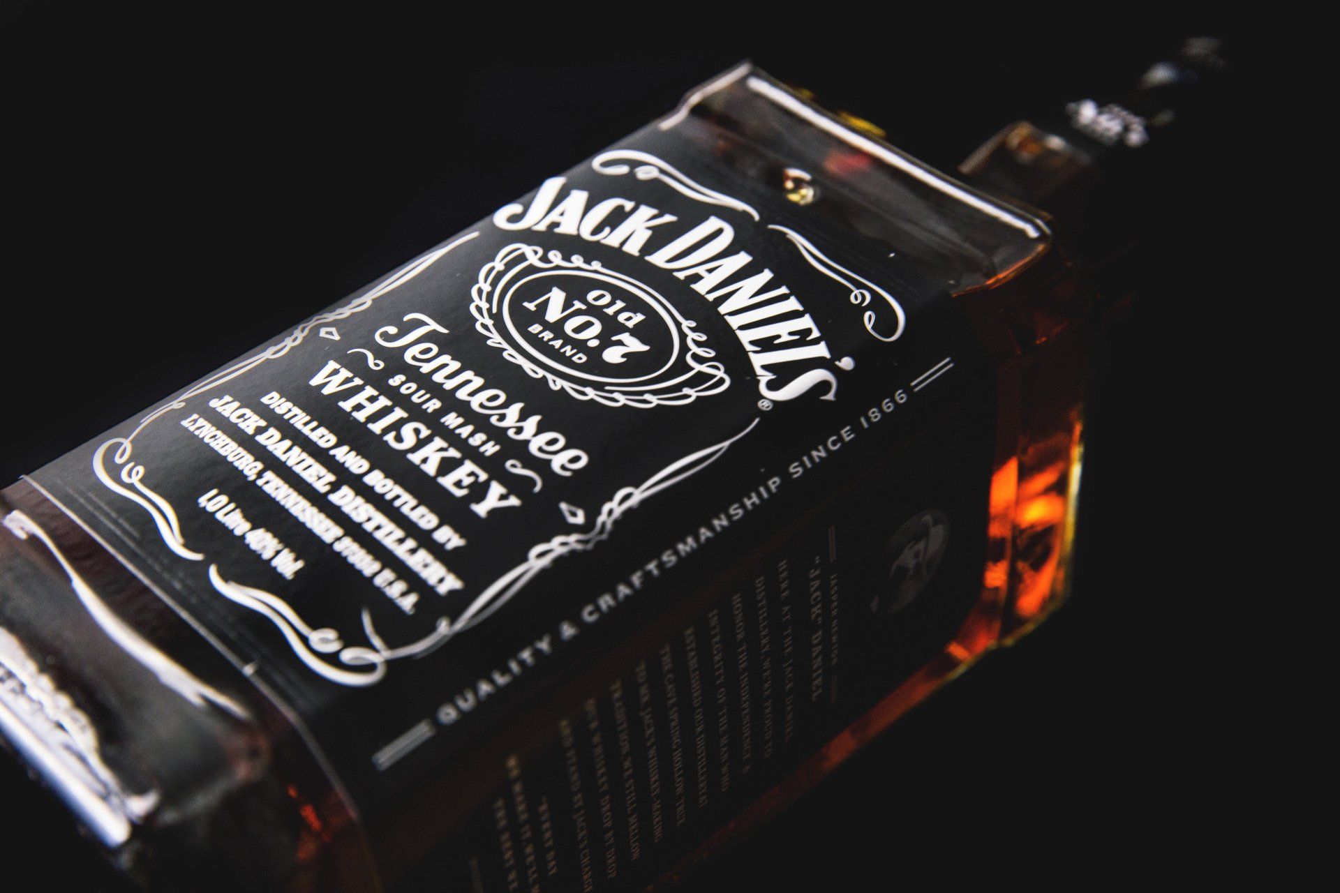 A bottle of jack daniel 's tennessee whiskey on a black background