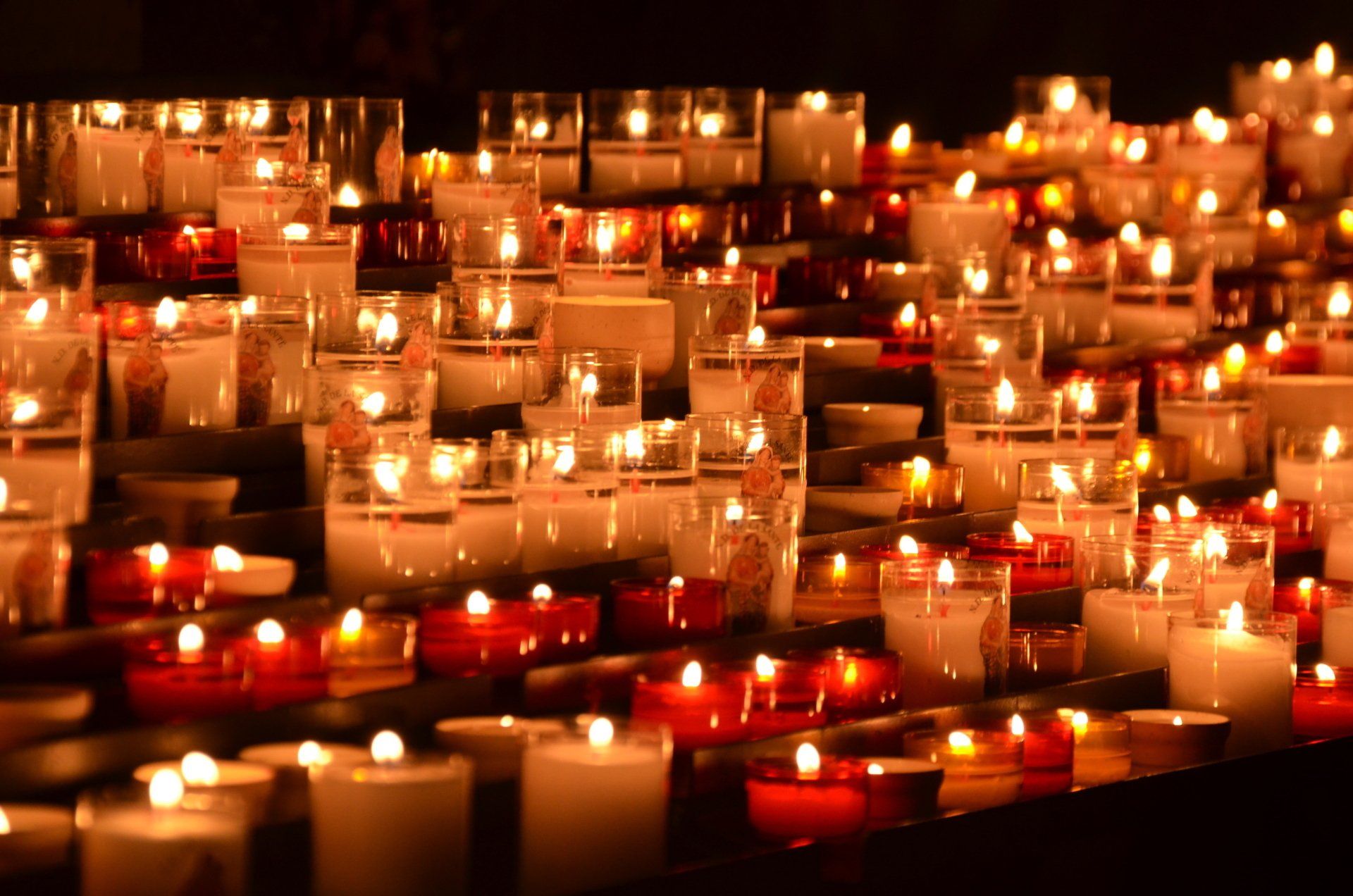 rows of orange and red prayer candles