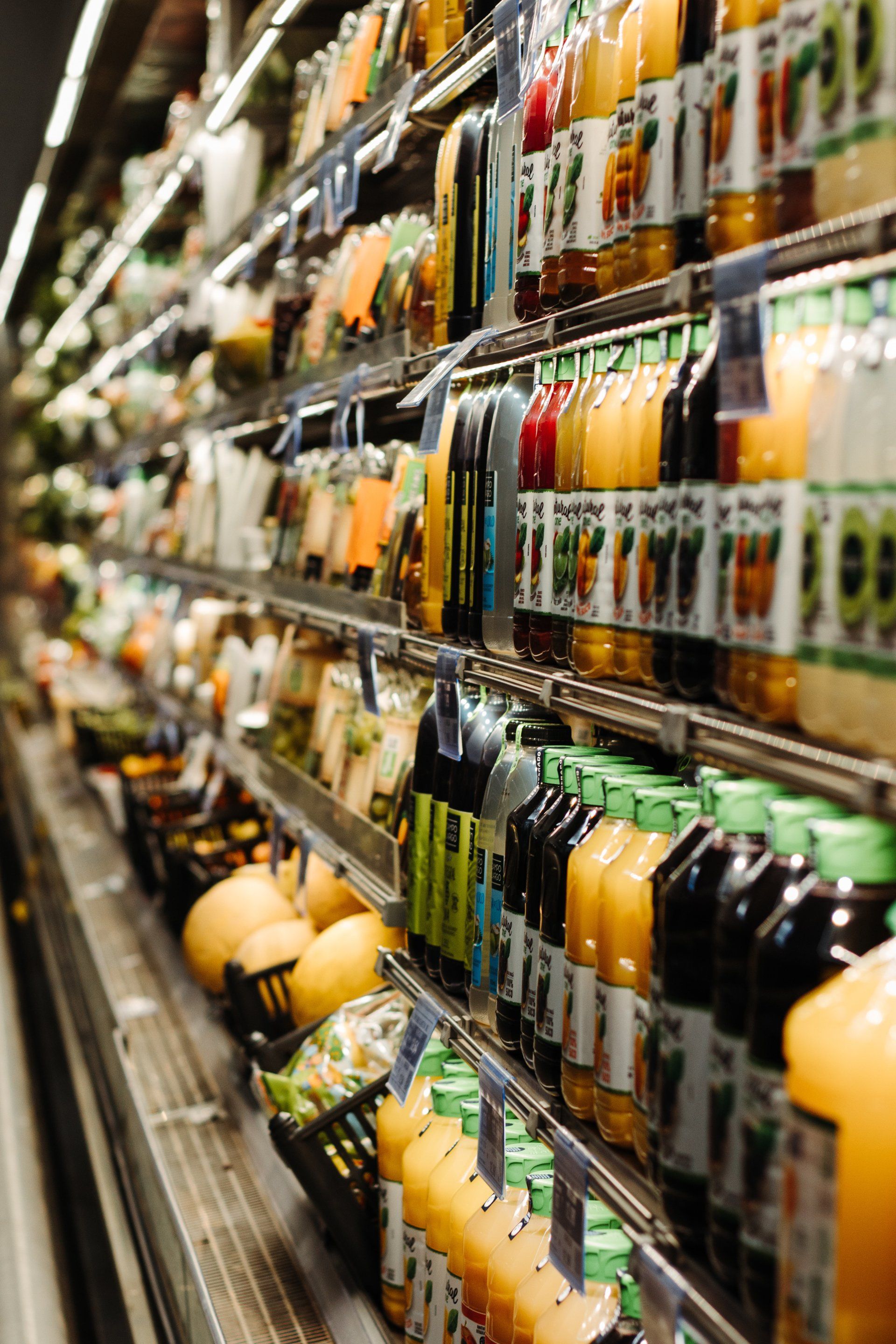 a grocery store aisle filled with fruits and juices .