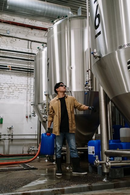 Technician inspecting industrial water filtration system in commercial plumbing environment
