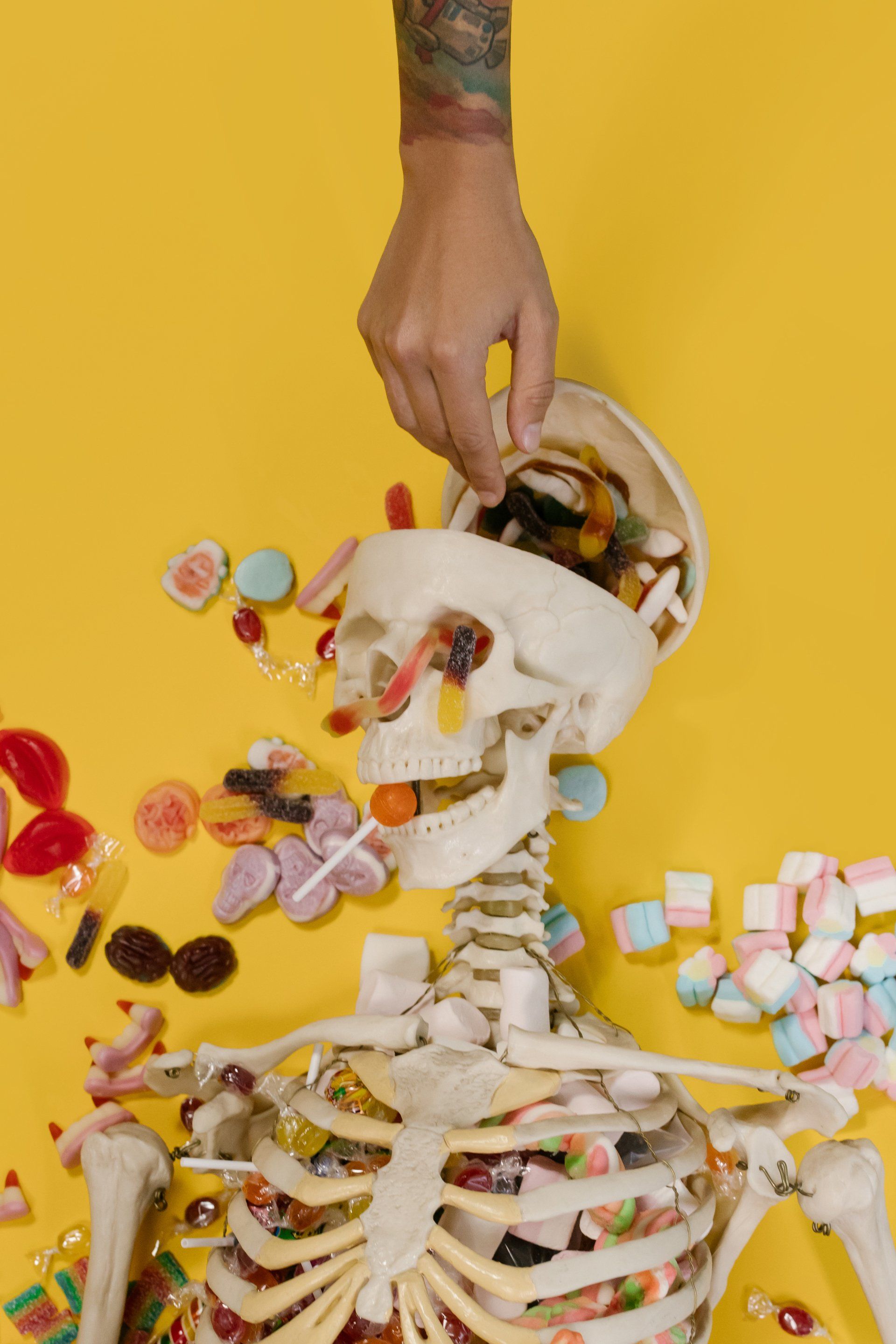 A person is putting candy into a skeleton 's mouth. Brainspotting Therapy in Texas .