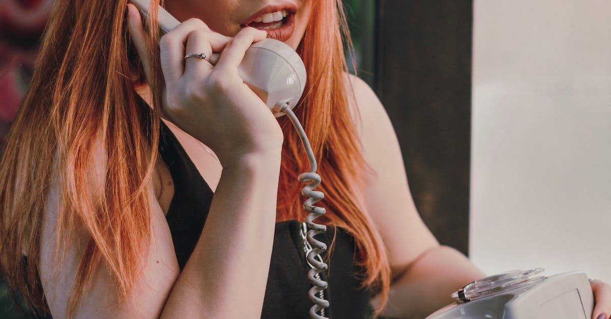 a woman with red hair is talking on a telephone .