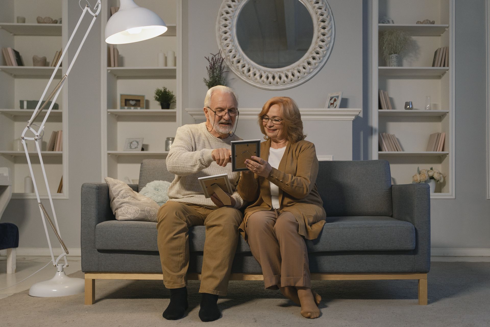 an old couple in a room looking at a photo