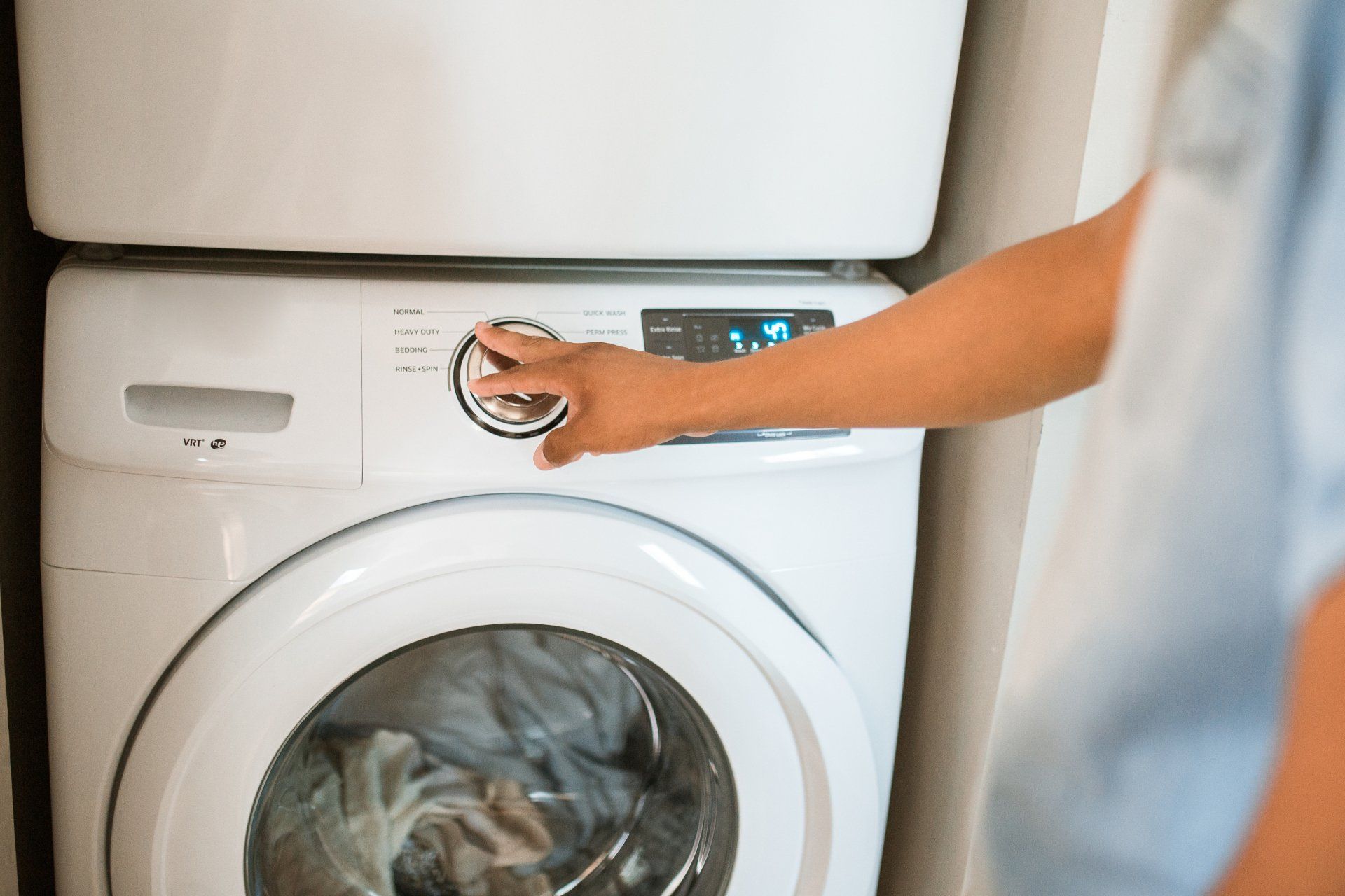 a person is pressing a button on a washing machine