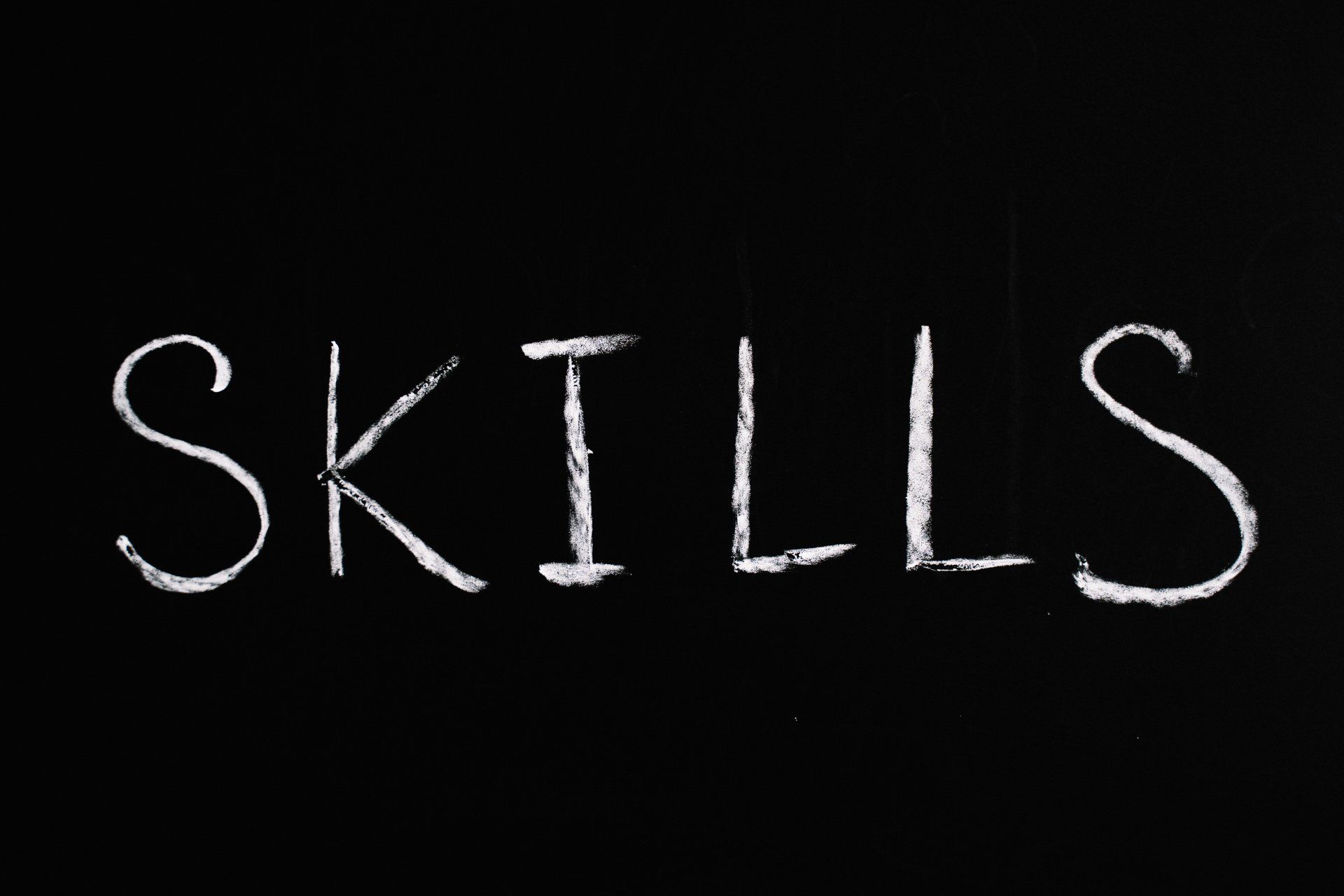 The word skills is written in white chalk on a blackboard.