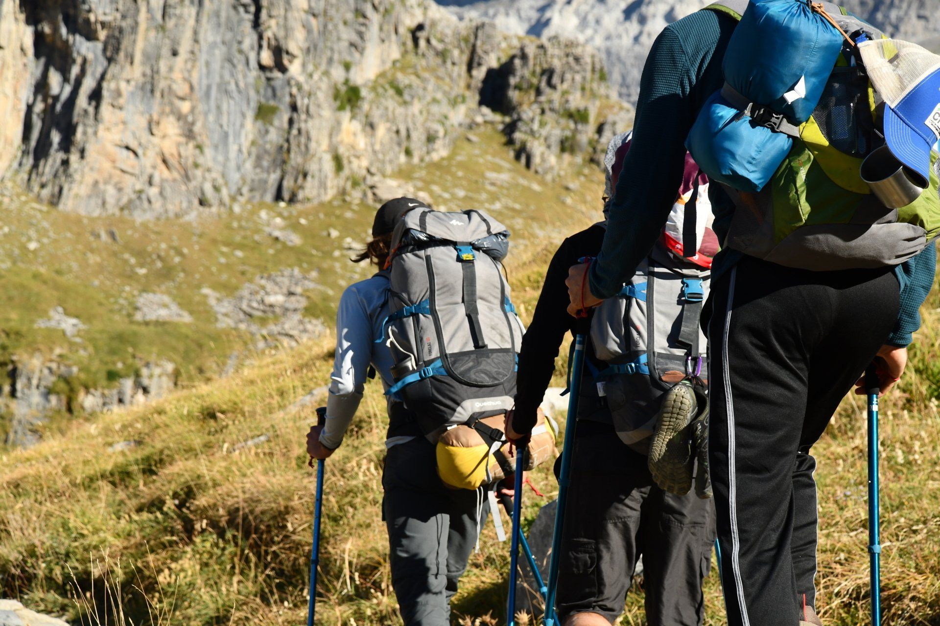 Un grupo de personas con mochilas están caminando por una colina.