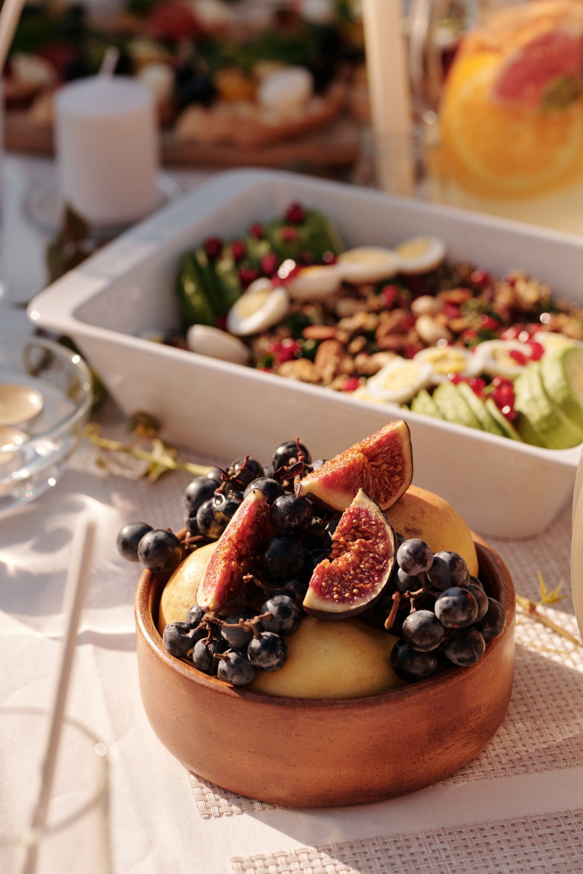 A wooden bowl filled with fruit and vegetables on a table.