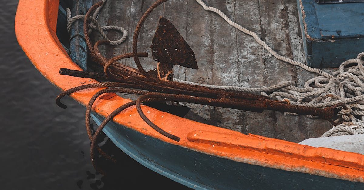 A close up of the side of a boat with ropes and an anchor.