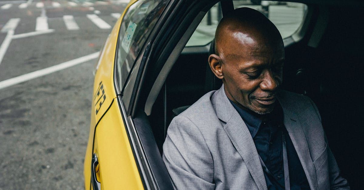A man in a suit is sitting in the back seat of a taxi.