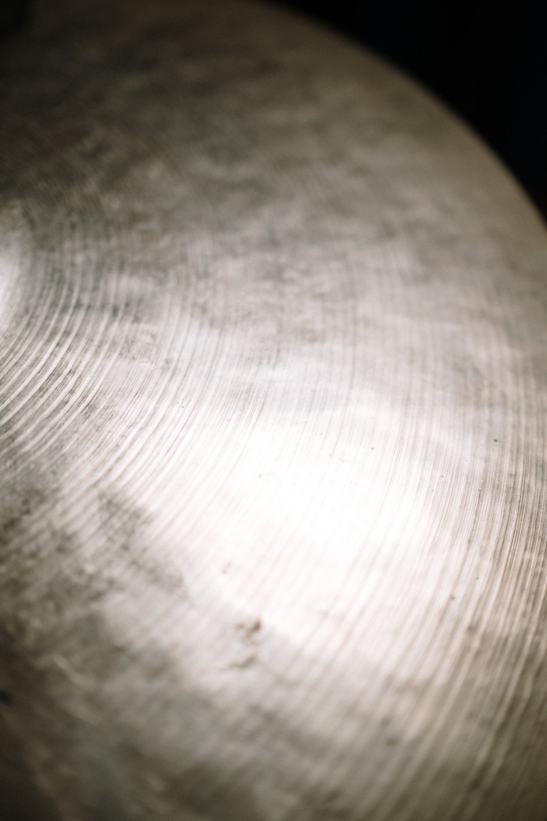 A close up of a cymbal with a light shining on it.