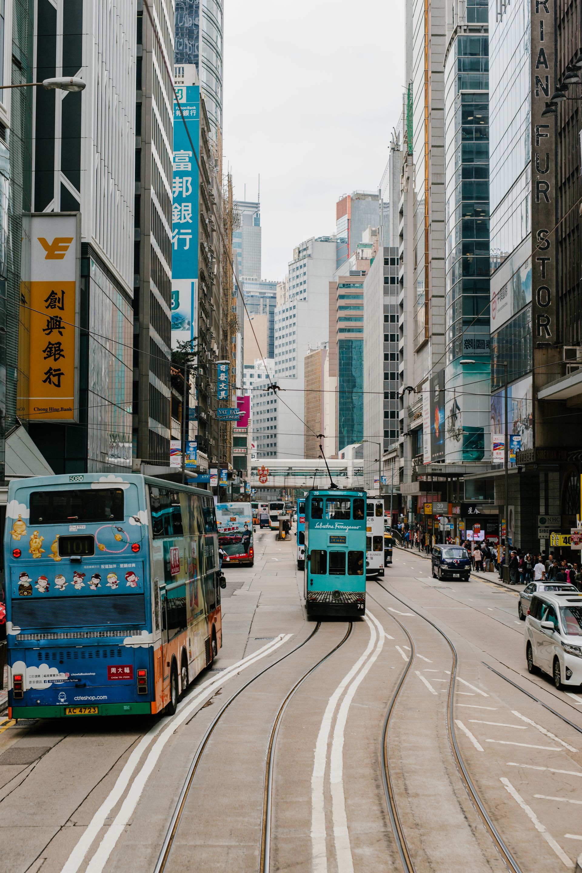 A double decker bus is driving down a busy city street.